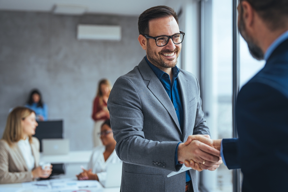 Business men shaking hands and smiling